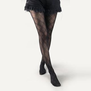 Black patterned tights worn with a black skirt on a white background